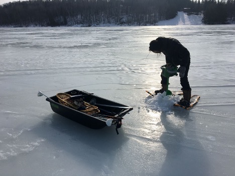 Image of researcher drilling through the ice